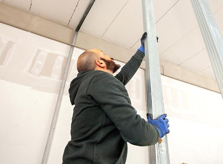 Technician installing steel studs during commercial build-out